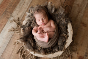 Temecula Newborn Photographer, little baby boy wrapped in light brown blanket asleep in wooden bowl